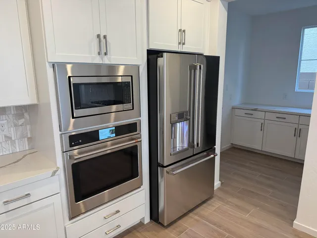 a metallic refrigerator freezer sitting in a kitchen