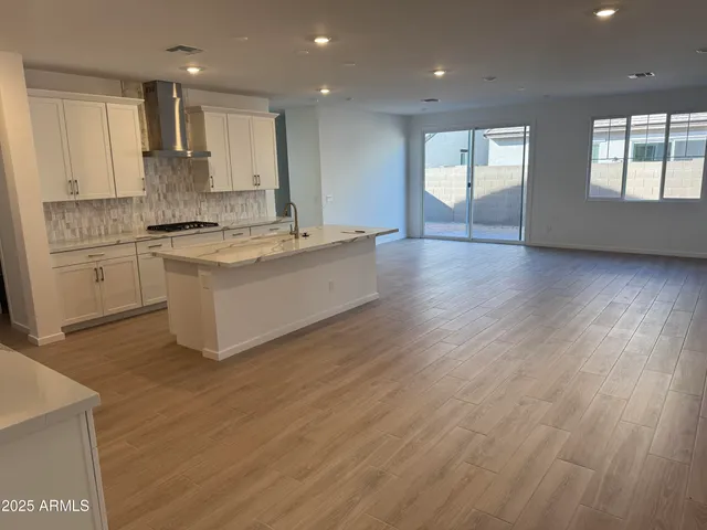 a large kitchen with stainless steel appliances granite countertop a large stove a sink dishwasher and a oven with white cabinets