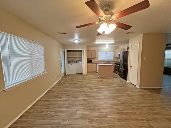 a large room with chandelier fan and windows