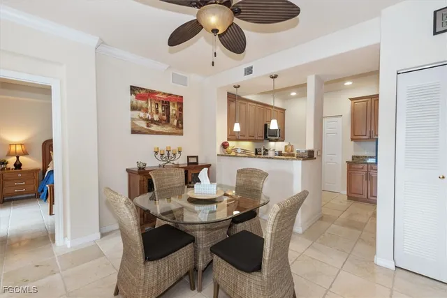 a dining room with furniture and a chandelier fan