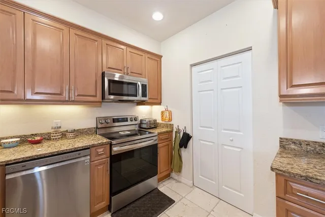 a kitchen with granite countertop a stove top oven microwave and cabinets