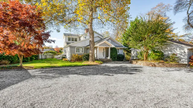 a view of a house with a big yard and large trees