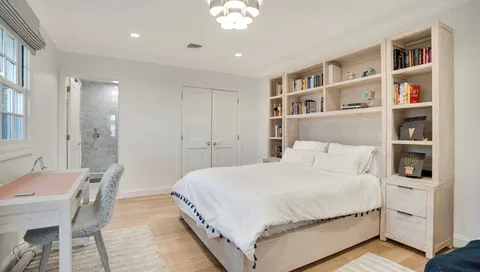 a bedroom with a large bed and a book shelf