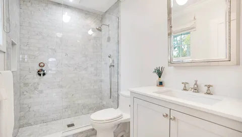 a bathroom with a sink a toilet and shower