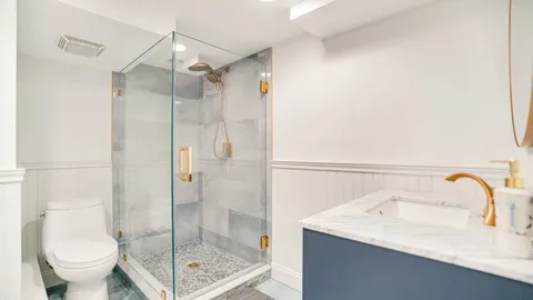 a bathroom with a granite countertop sink a toilet and shower