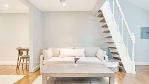 a white couch sitting next to a white cabinet