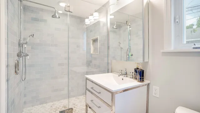 a bathroom with a sink a shower and a mirror