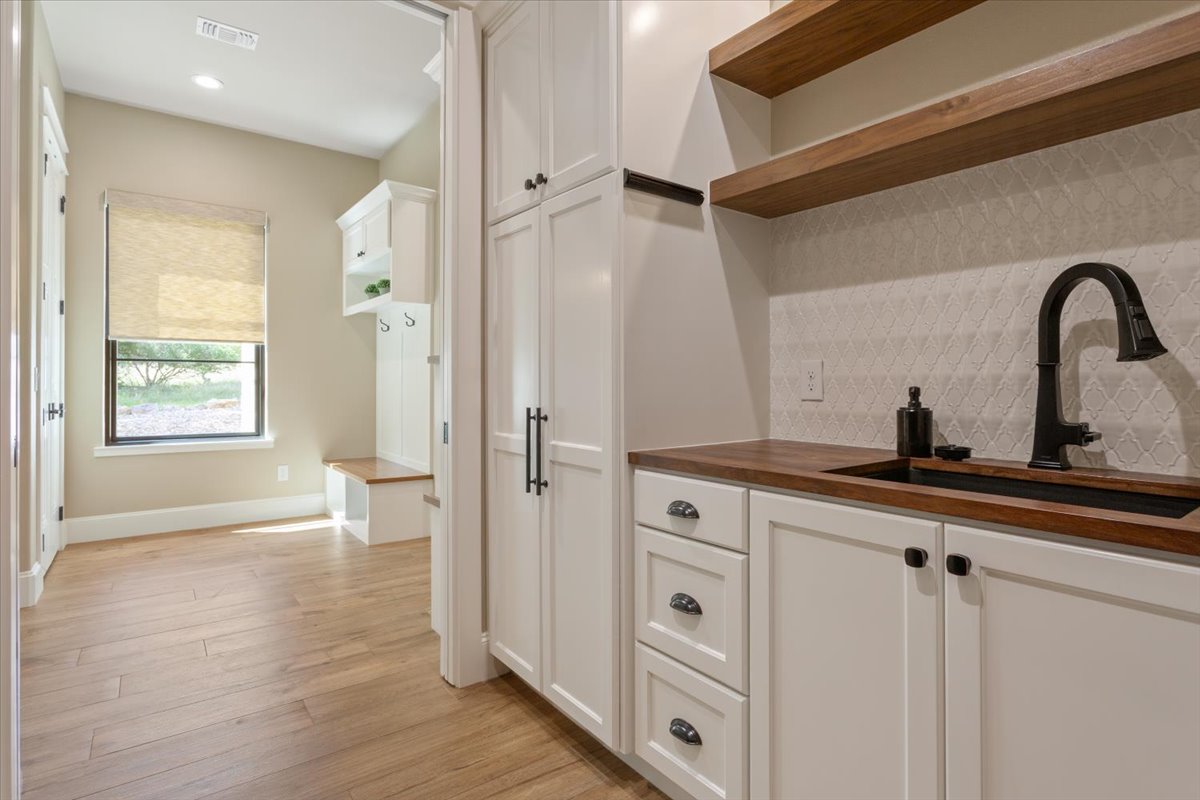 309 Highland Spring Lane Georgetown, TX 78633 - Photo 17 of 40 On the right of the Utility Room, another Blanco brand sink with cabinets, drawers, a closet for brooms & vacuums, & floating Walnut shelves...