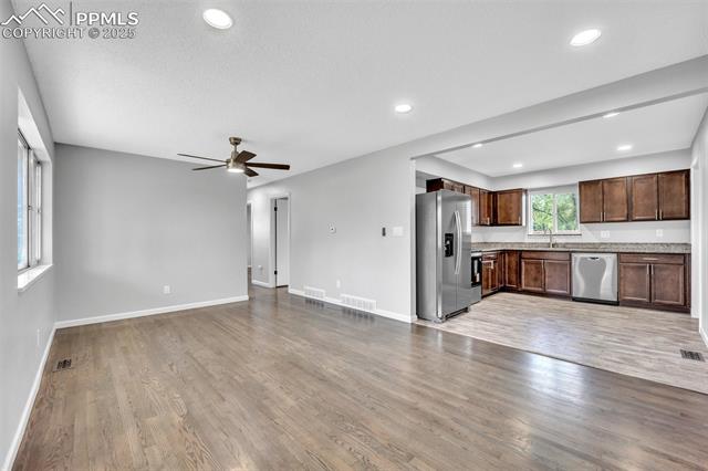2004 Monterey Road Colorado Springs, CO 80910 - Photo 5 of 27 Unfurnished living room featuring ceiling fan, wood finished floors, recessed lighting, and a textured ceiling