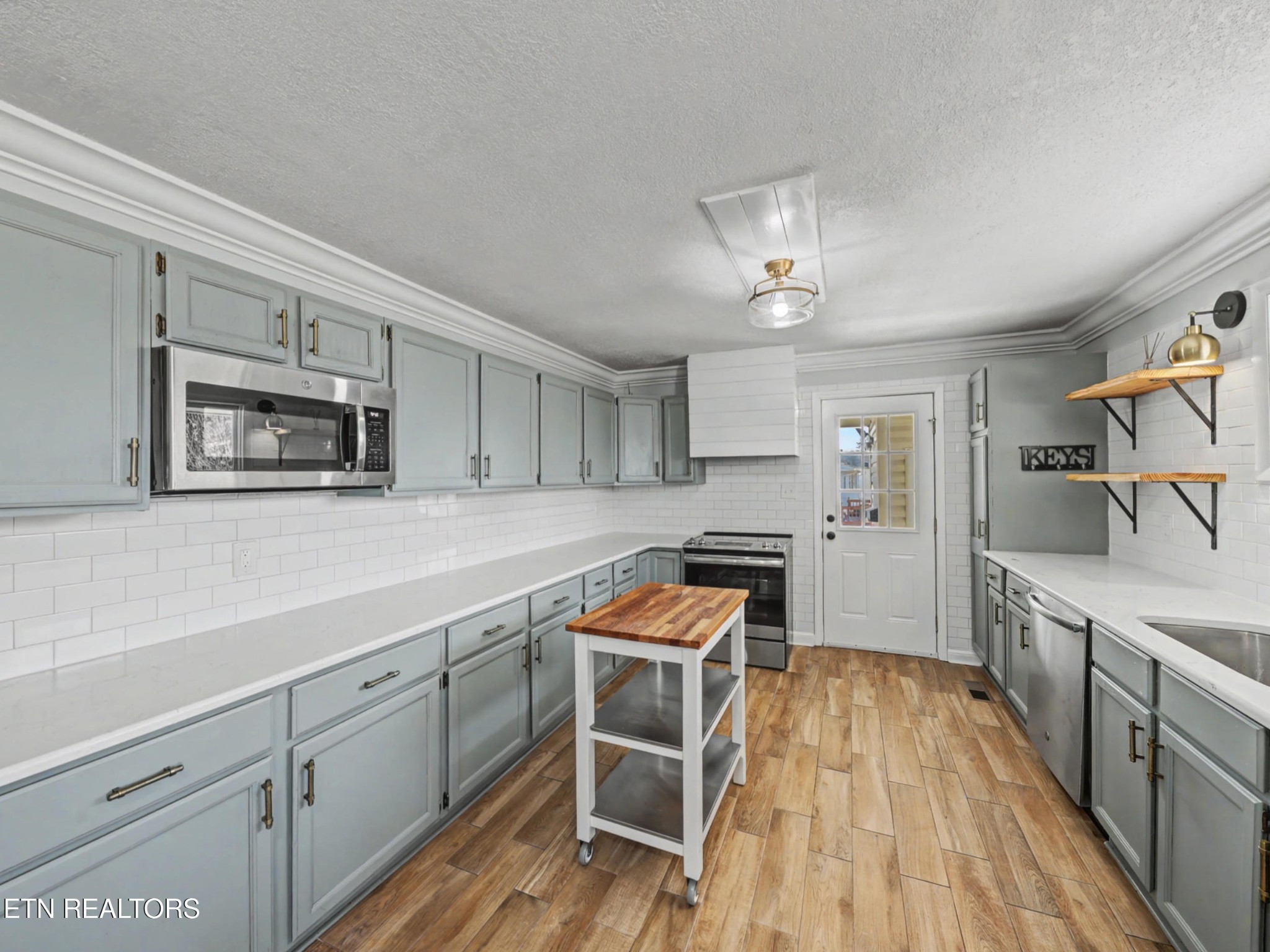 209 Wakefield Road Knoxville, TN 37922 - Photo 9 of 29 a kitchen with stainless steel appliances a stove a sink cabinets and a wooden floor