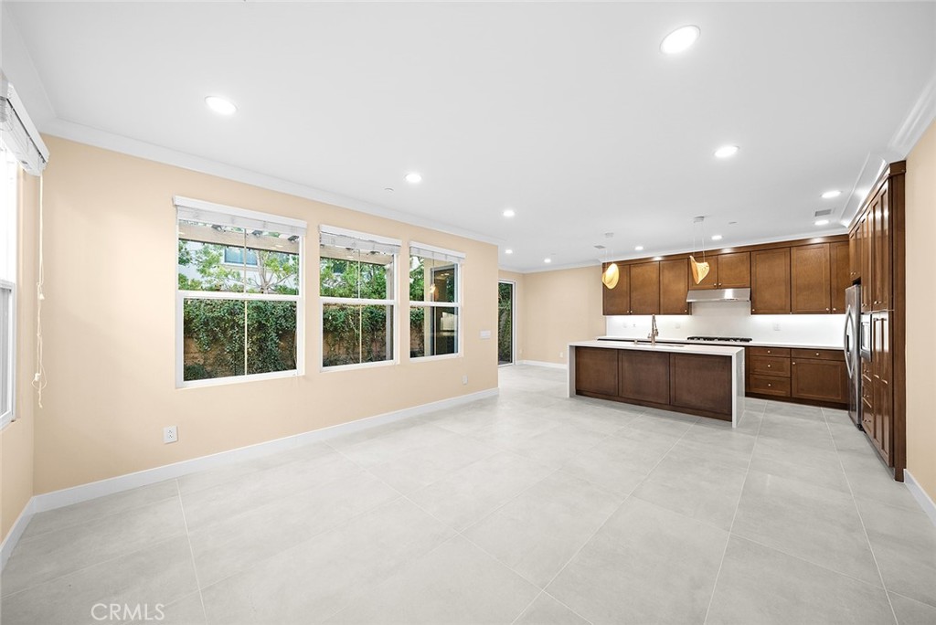 143 Rodeo Irvine, CA 92602 - Photo 8 of 37 a large white kitchen with a large window and kitchen island