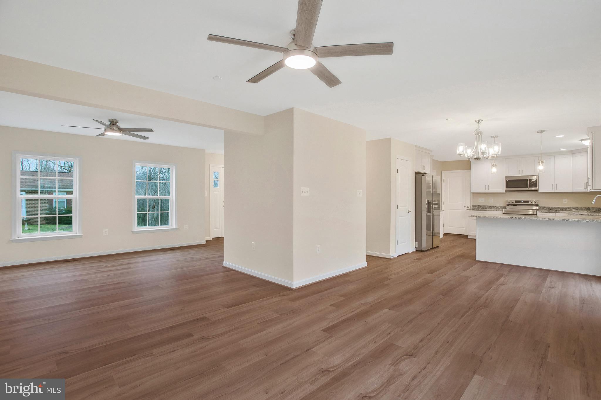 11541 Bootstrap Trail Lusby, MD 20657 - Photo 11 of 24 a view of an empty room with wooden floor and a kitchen