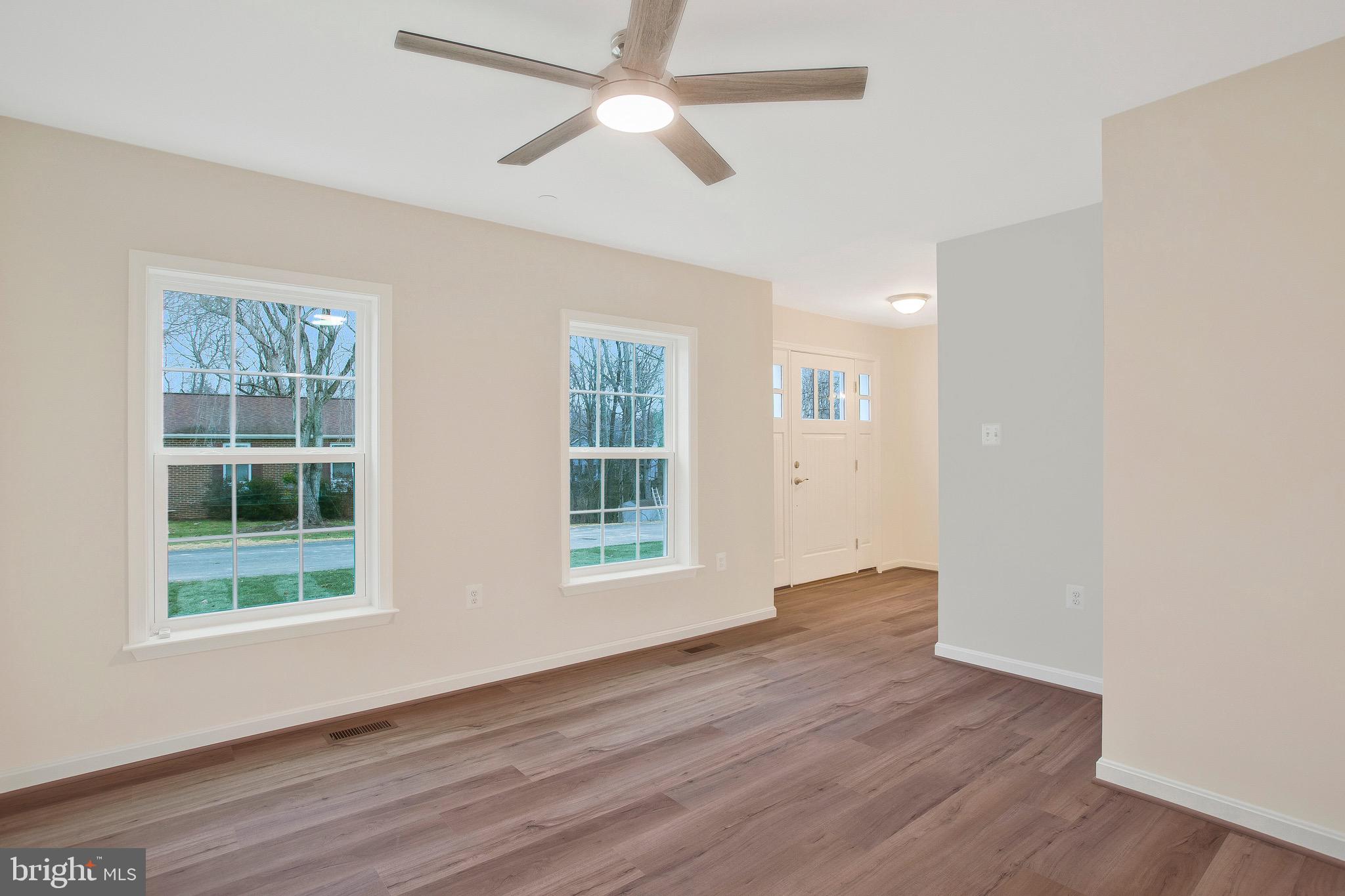 11541 Bootstrap Trail Lusby, MD 20657 - Photo 12 of 24 an empty room with wooden floor chandelier fan and windows