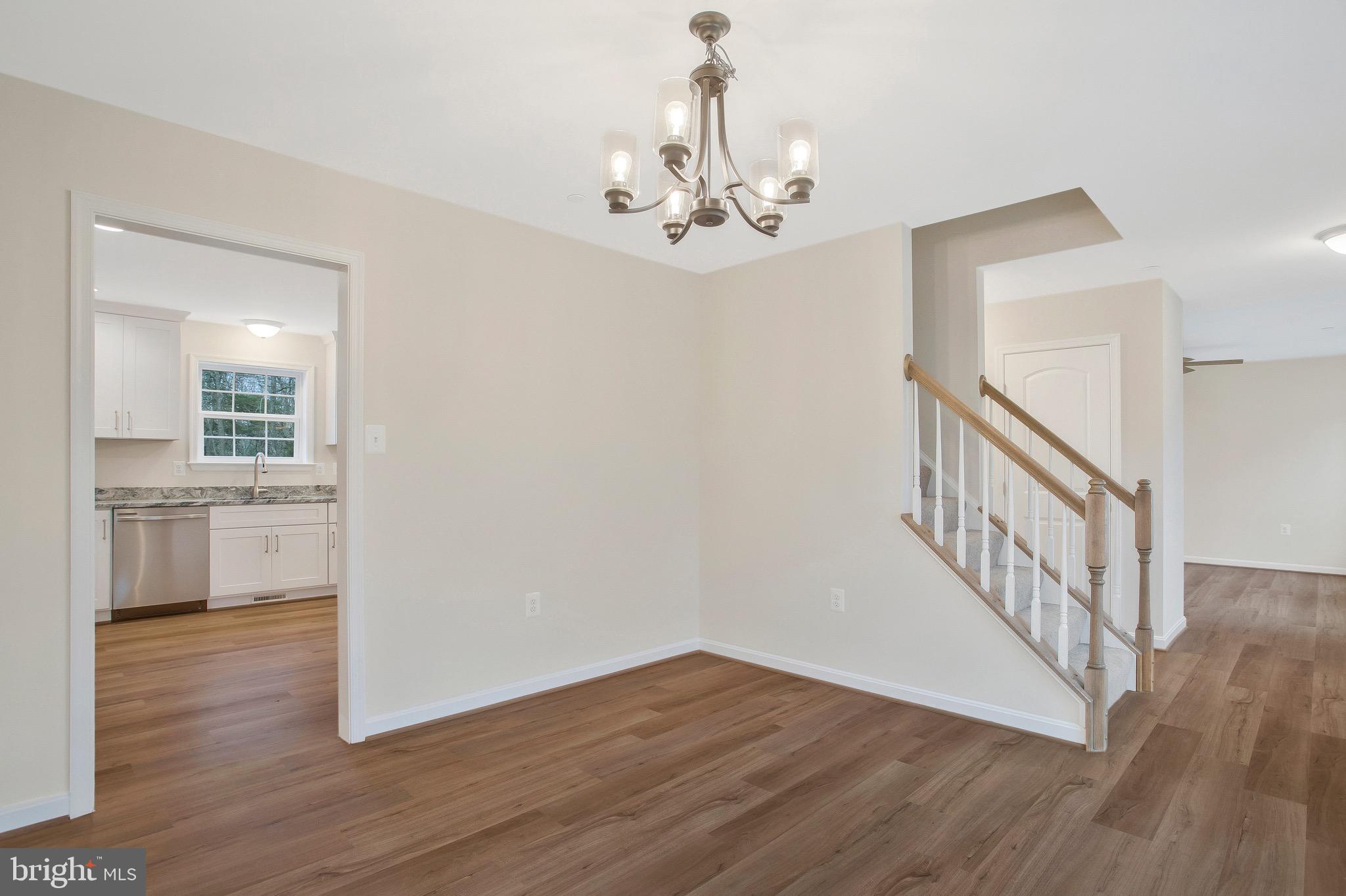 11541 Bootstrap Trail Lusby, MD 20657 - Photo 3 of 24 a view of a hallway with wooden floor and a kitchen
