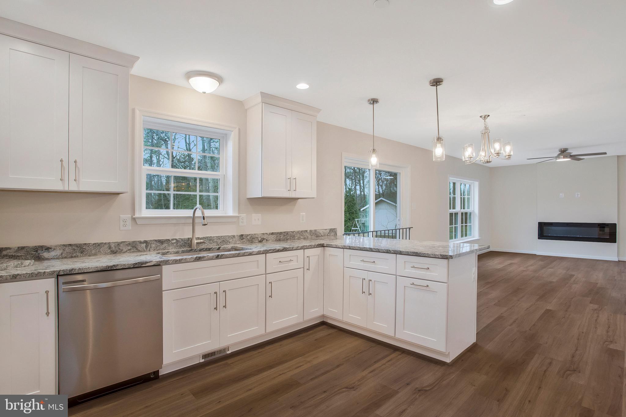 11541 Bootstrap Trail Lusby, MD 20657 - Photo 7 of 24 a large kitchen with granite countertop a white stove top oven sink and cabinets