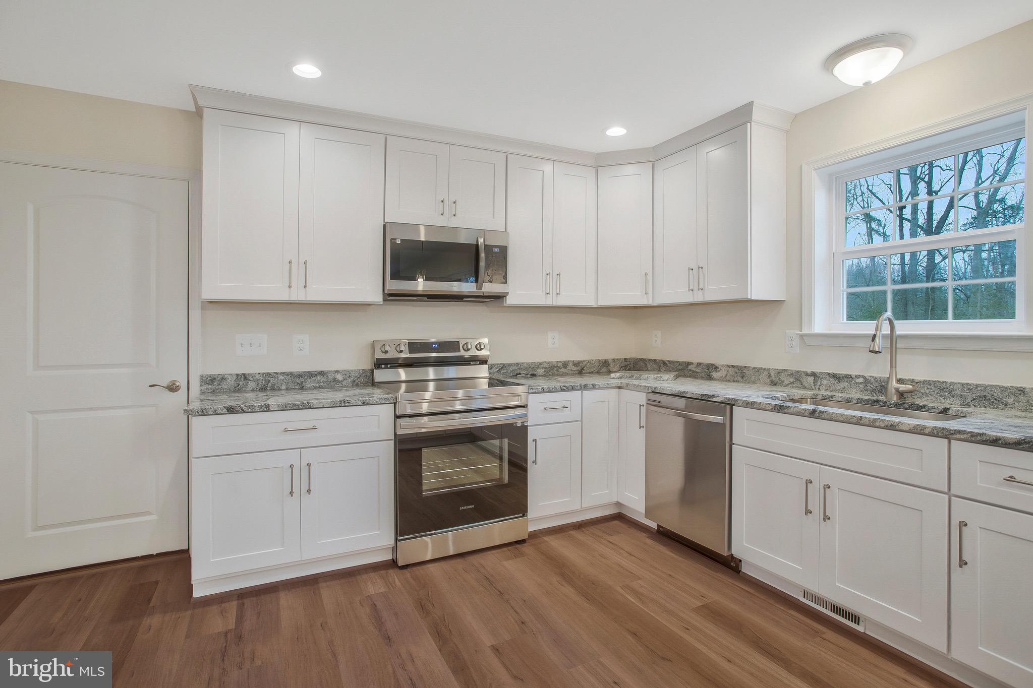 11541 Bootstrap Trail Lusby, MD 20657 - Photo 9 of 24 a kitchen with granite countertop a sink cabinets and stainless steel appliances
