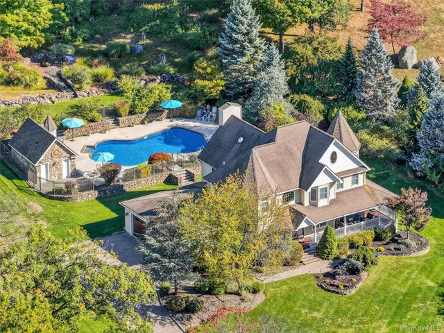 an aerial view of a house with a yard and outdoor seating