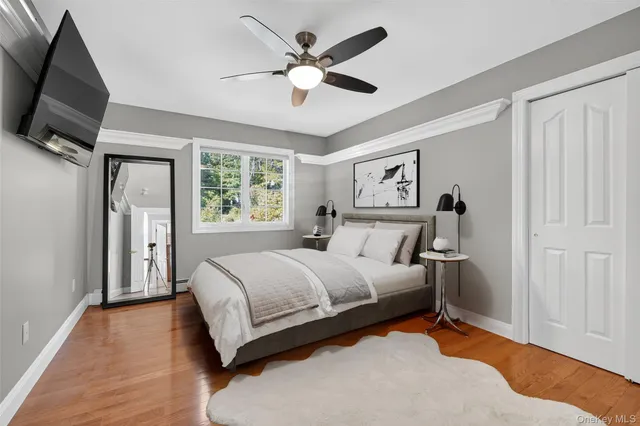 a spacious bedroom with a bed and a flat screen tv