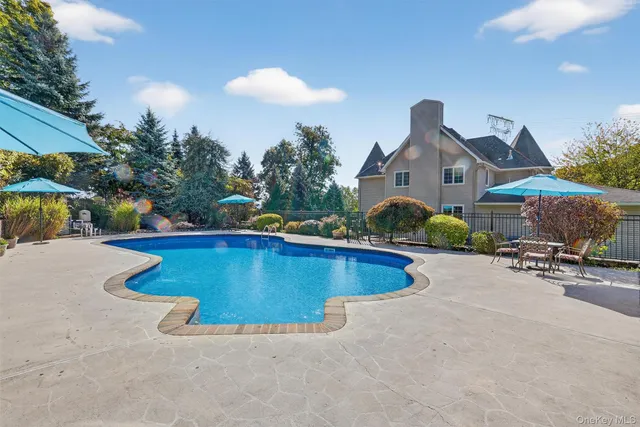 a view of a house with swimming pool and sitting area