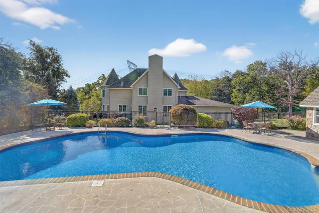 a view of a house with pool and chairs