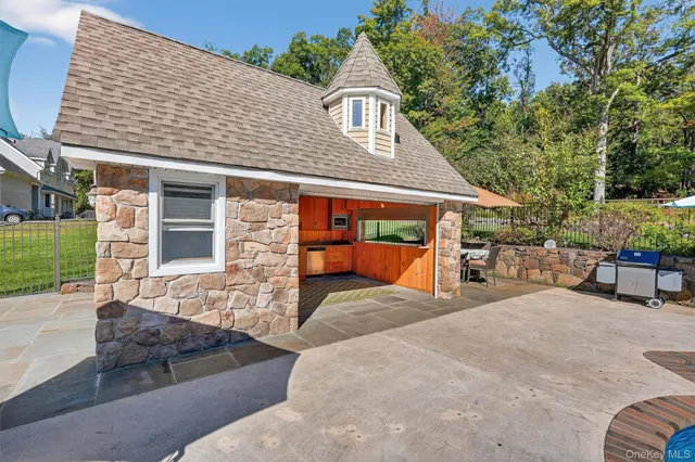 a view of a house with a patio and a yard