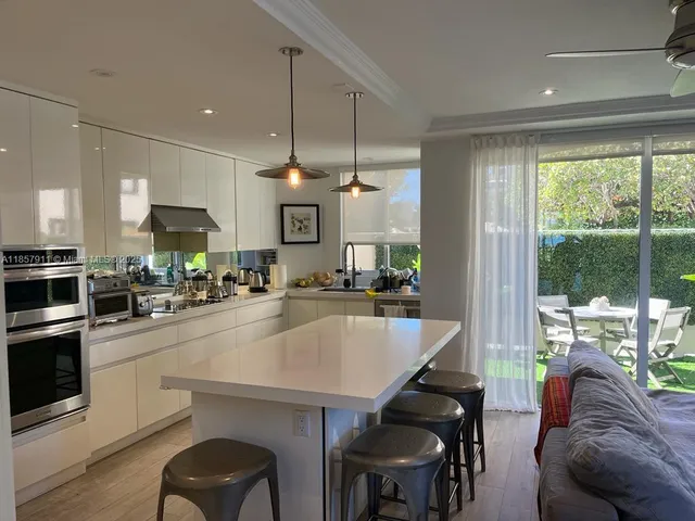 a kitchen with a table chairs microwave and cabinets