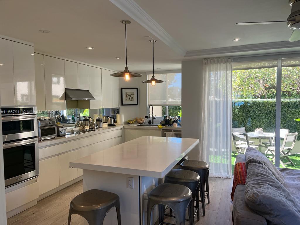 201 Crandon Boulevard, Unit 177 Key Biscayne, FL 33149 - Photo 11 of 24 a kitchen with a table chairs microwave and cabinets