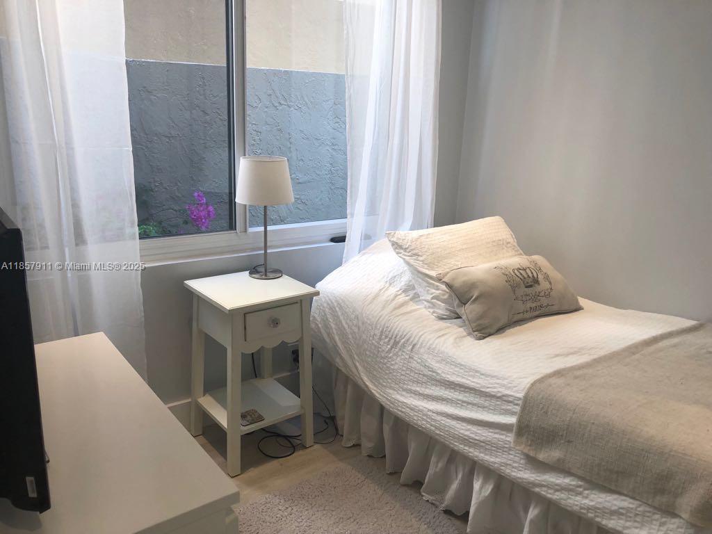 201 Crandon Boulevard, Unit 177 Key Biscayne, FL 33149 - Photo 15 of 24 a bedroom with a bed and a table