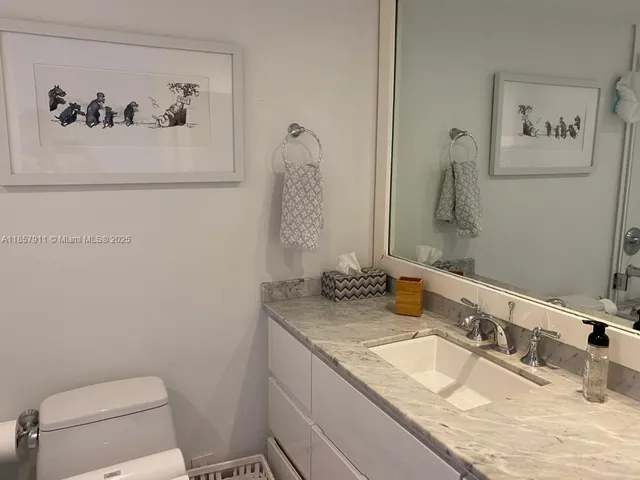 a bathroom with a granite countertop sink mirror and toilet