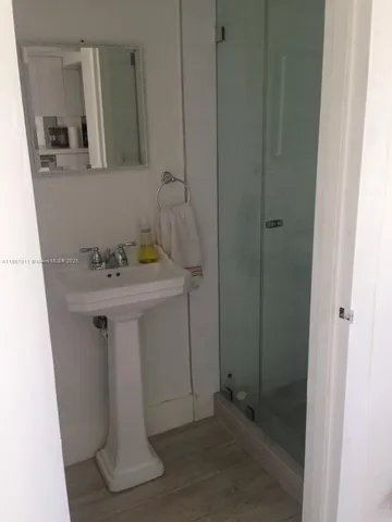 a bathroom with a sink a mirror and shower