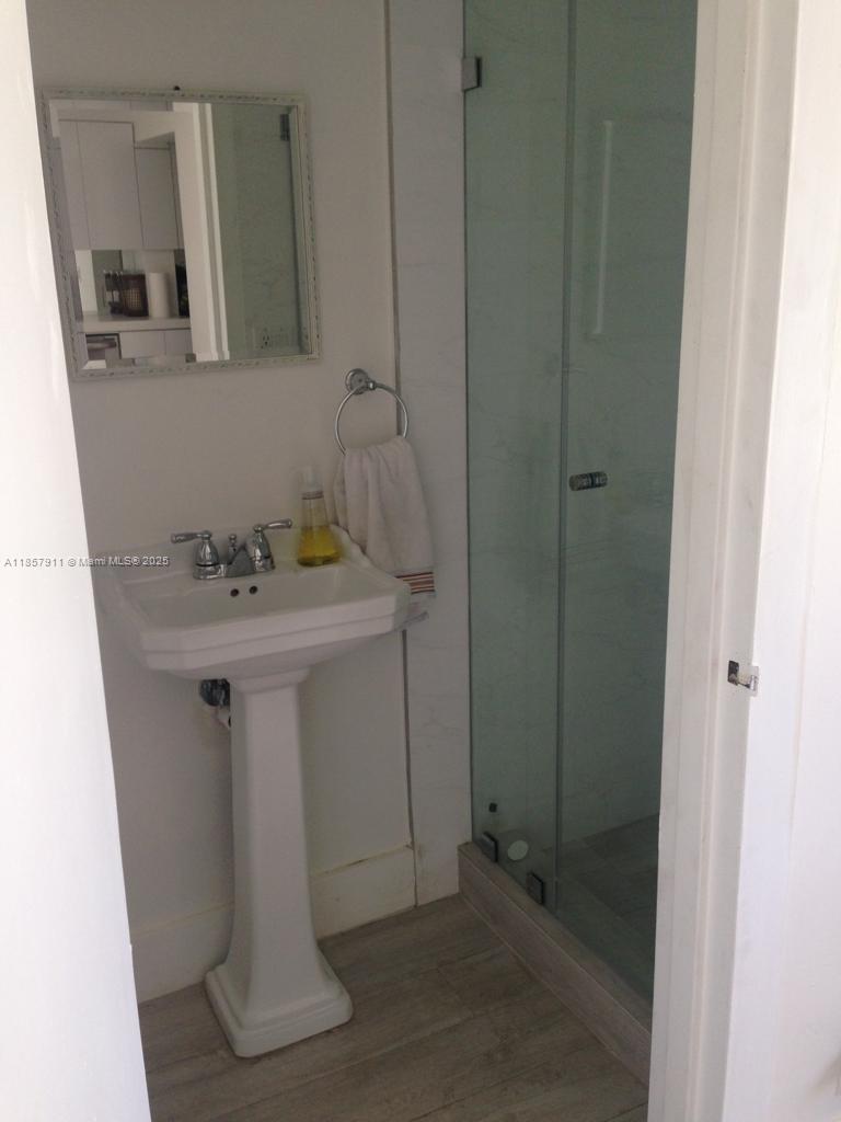 201 Crandon Boulevard, Unit 177 Key Biscayne, FL 33149 - Photo 18 of 24 a bathroom with a sink a mirror and shower