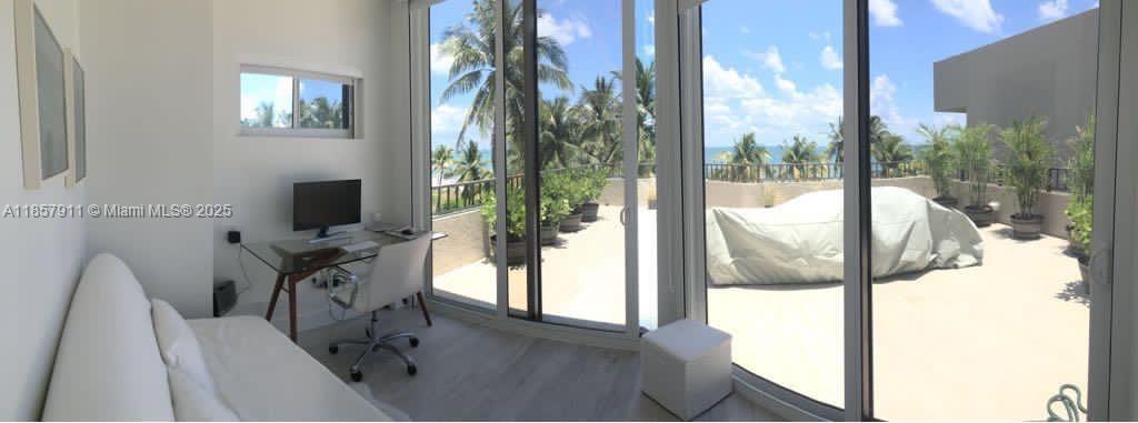 201 Crandon Boulevard, Unit 177 Key Biscayne, FL 33149 - Photo 19 of 24 a living room with furniture a flat screen tv and a floor to ceiling window