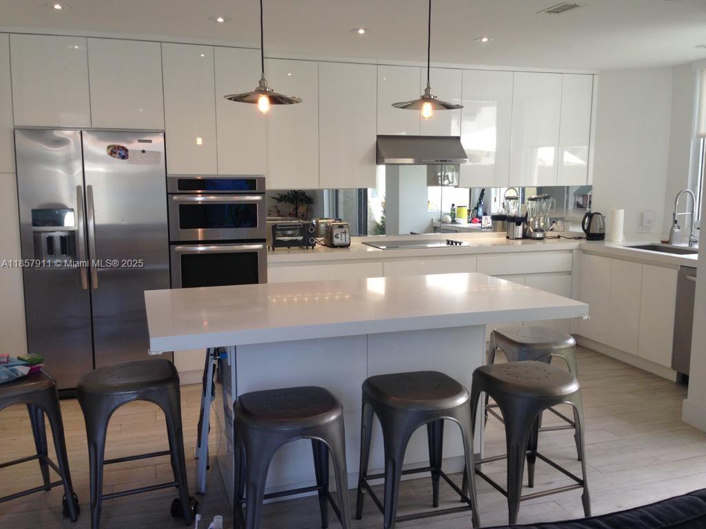 201 Crandon Boulevard, Unit 177 Key Biscayne, FL 33149 - Photo 10 of 24 a kitchen with refrigerator a sink and chairs