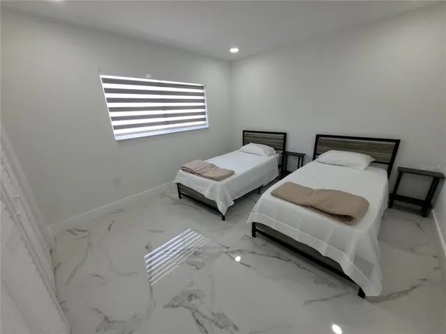 a bedroom with two beds and a window