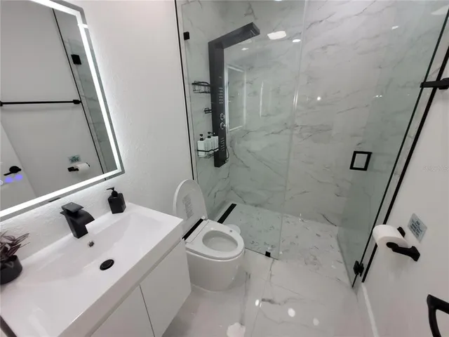 a bathroom with a sink mirror vanity and toilet