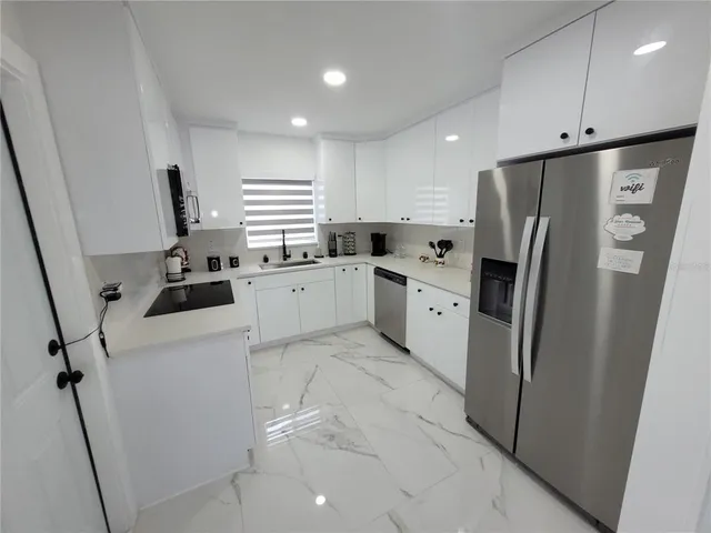 a kitchen with white cabinets and white stainless steel appliances