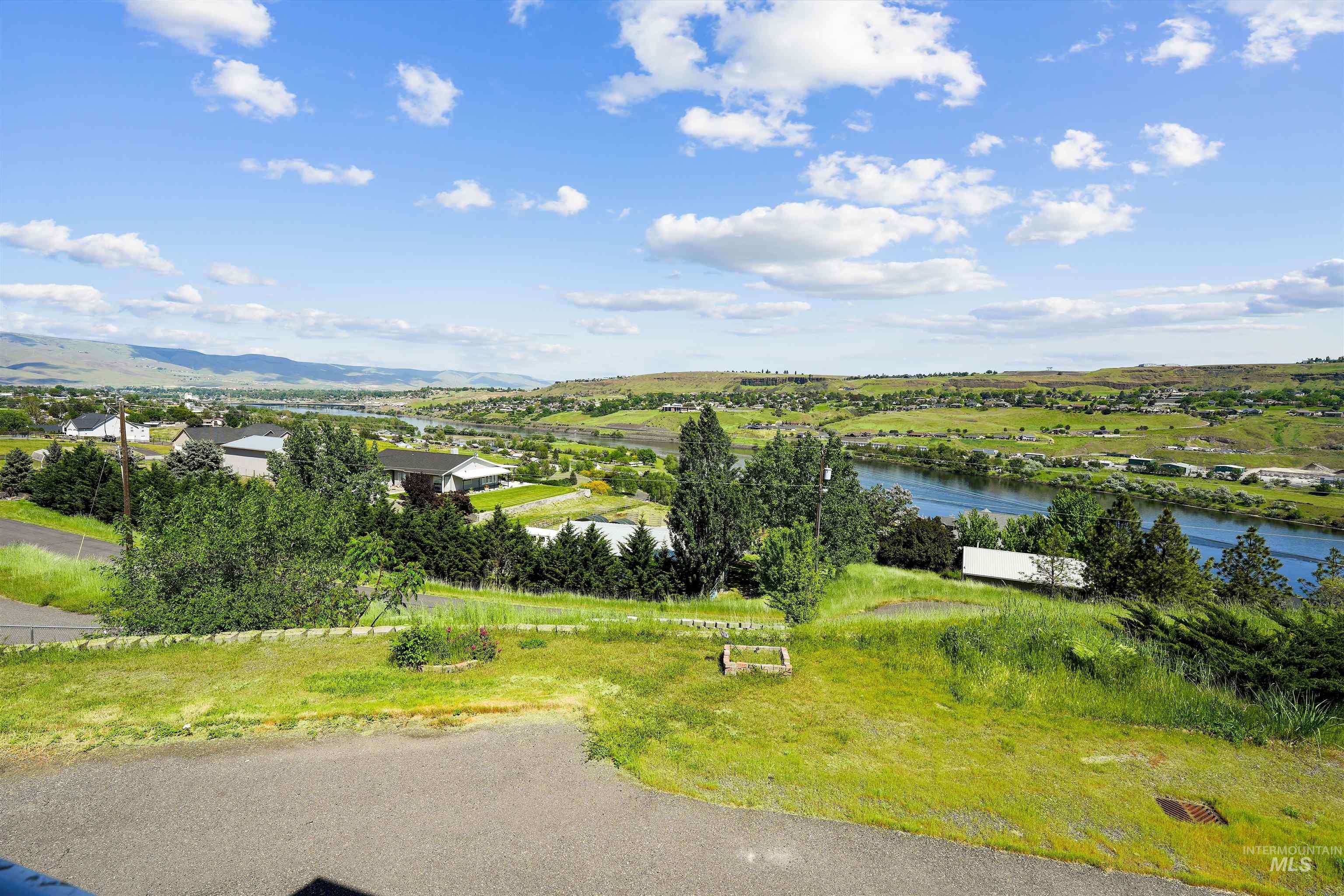 2750 South Perry Lane Clarkston, WA 99403 - Photo 12 of 47 Expansive landscape featuring a wide river, distant mountains, and scattered residential properties across rolling green terrain