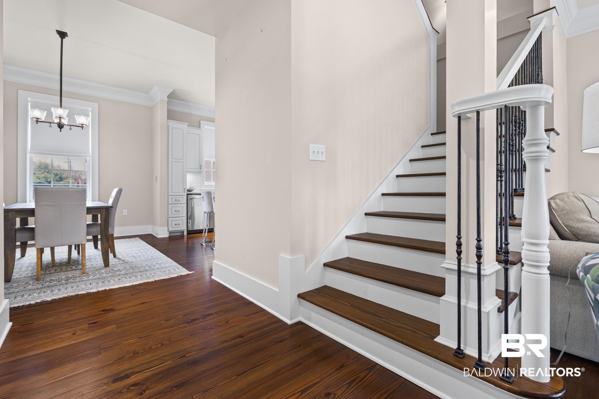 701 Dauphin Street, Unit A Mobile, AL 36602 - Photo 8 of 31 Hardwood flooring extends throughout the main level, complemented by a staircase featuring white risers and dark wood treads with black iron balusters