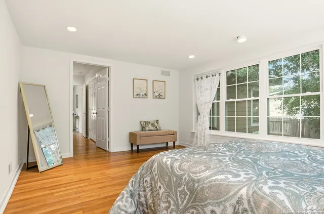 a spacious bedroom with a large bed and a large window