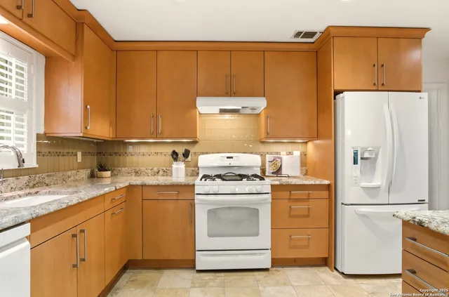 a kitchen with a stove top oven sink and refrigerator