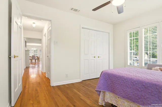a spacious bedroom with a bed and wooden floor