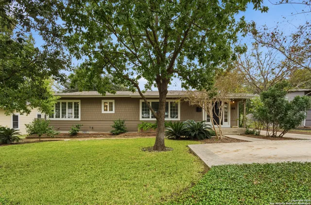 a front view of a house with a yard and trees
