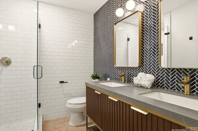 a bathroom with a sink a toilet and shower