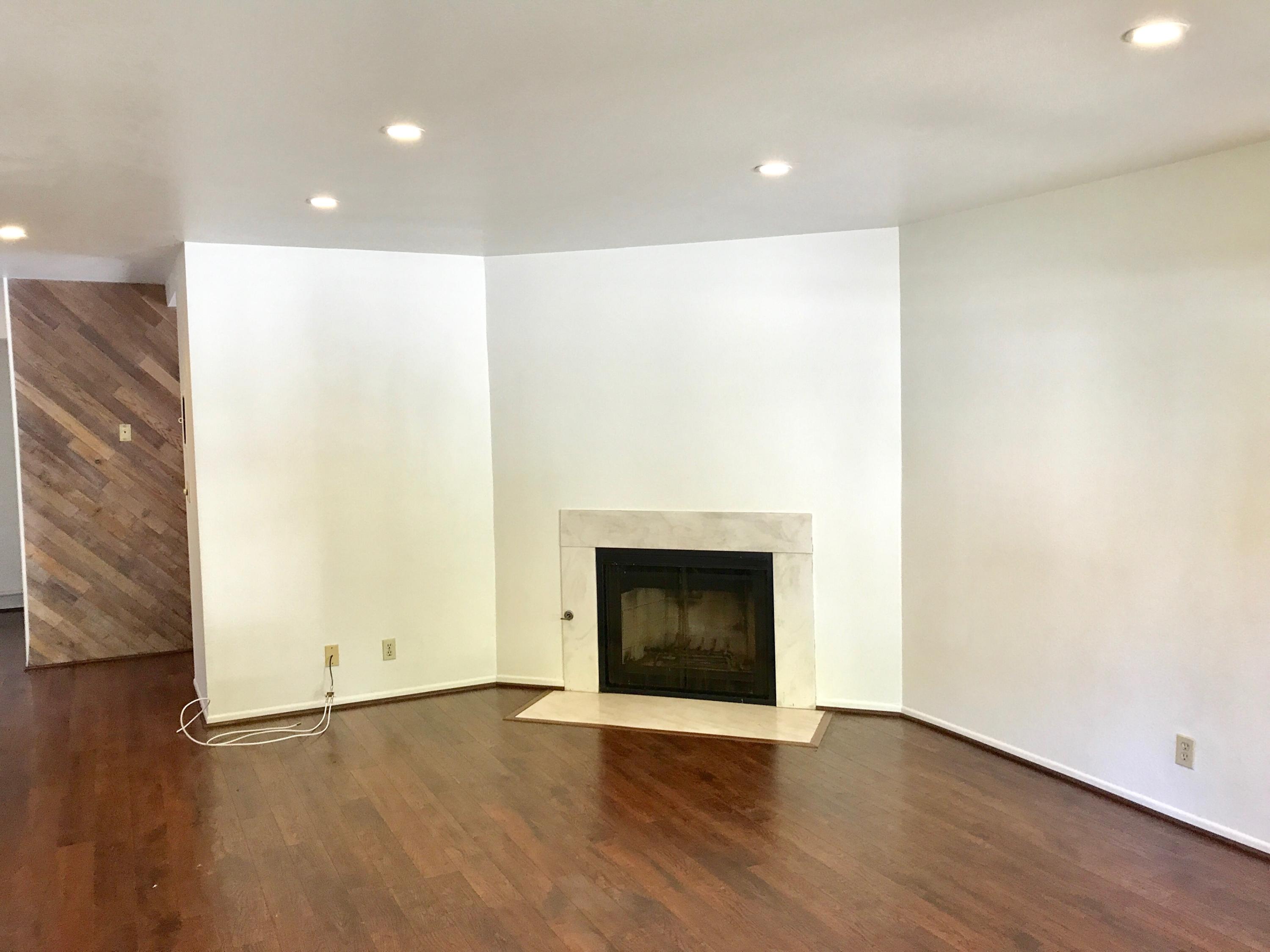 1815 Bath Street, Unit 1 Santa Barbara, CA 93101 - Photo 3 of 19 a view of an empty room with wooden floor and a fireplace