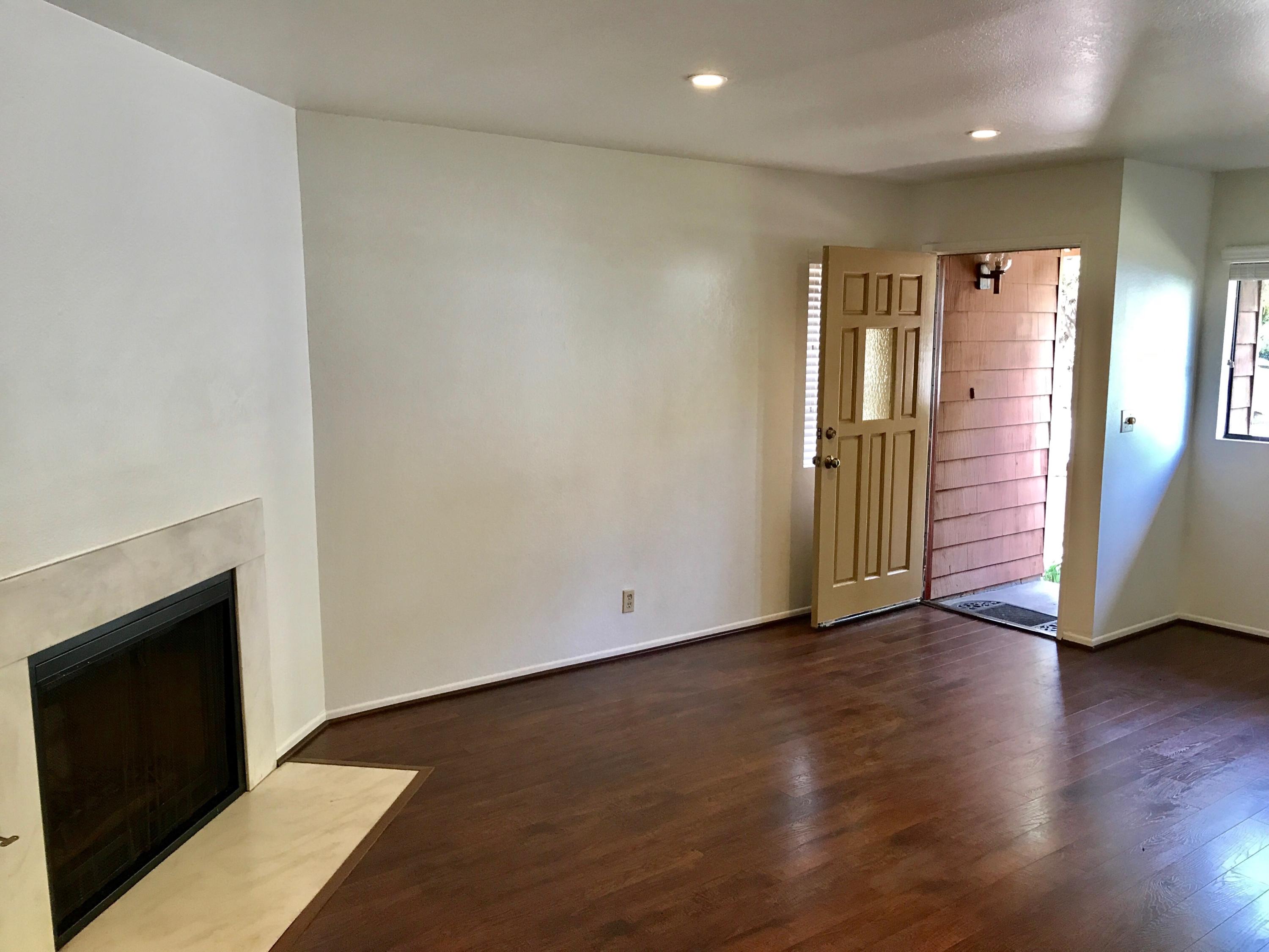 1815 Bath Street, Unit 1 Santa Barbara, CA 93101 - Photo 4 of 19 an empty room with wooden floor and a fireplace