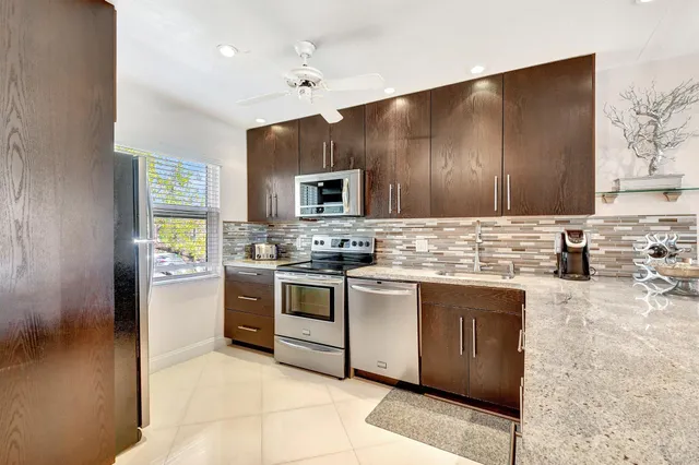 a kitchen with stainless steel appliances granite countertop a stove a sink and a refrigerator