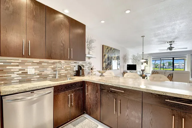 a kitchen with stainless steel appliances granite countertop a sink and dishwasher with wooden cabinets
