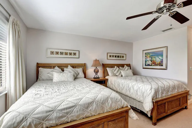 a bedroom with two beds and a large window