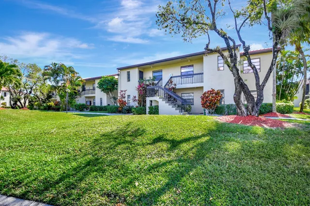 a view of a house with a yard and potted plants