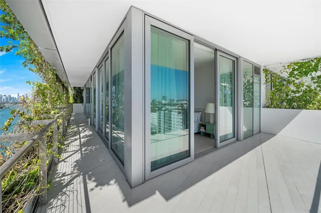 a living room with patio furniture and a floor to ceiling window